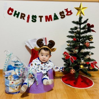 婚活卒業生の7ヶ月の赤ちゃん。クリスマスツリーの横でトナカイ姿をした可愛らしい赤ちゃんの写真。結婚相談所T&Hベストパートナーの成婚後の幸せな家族の様子。
